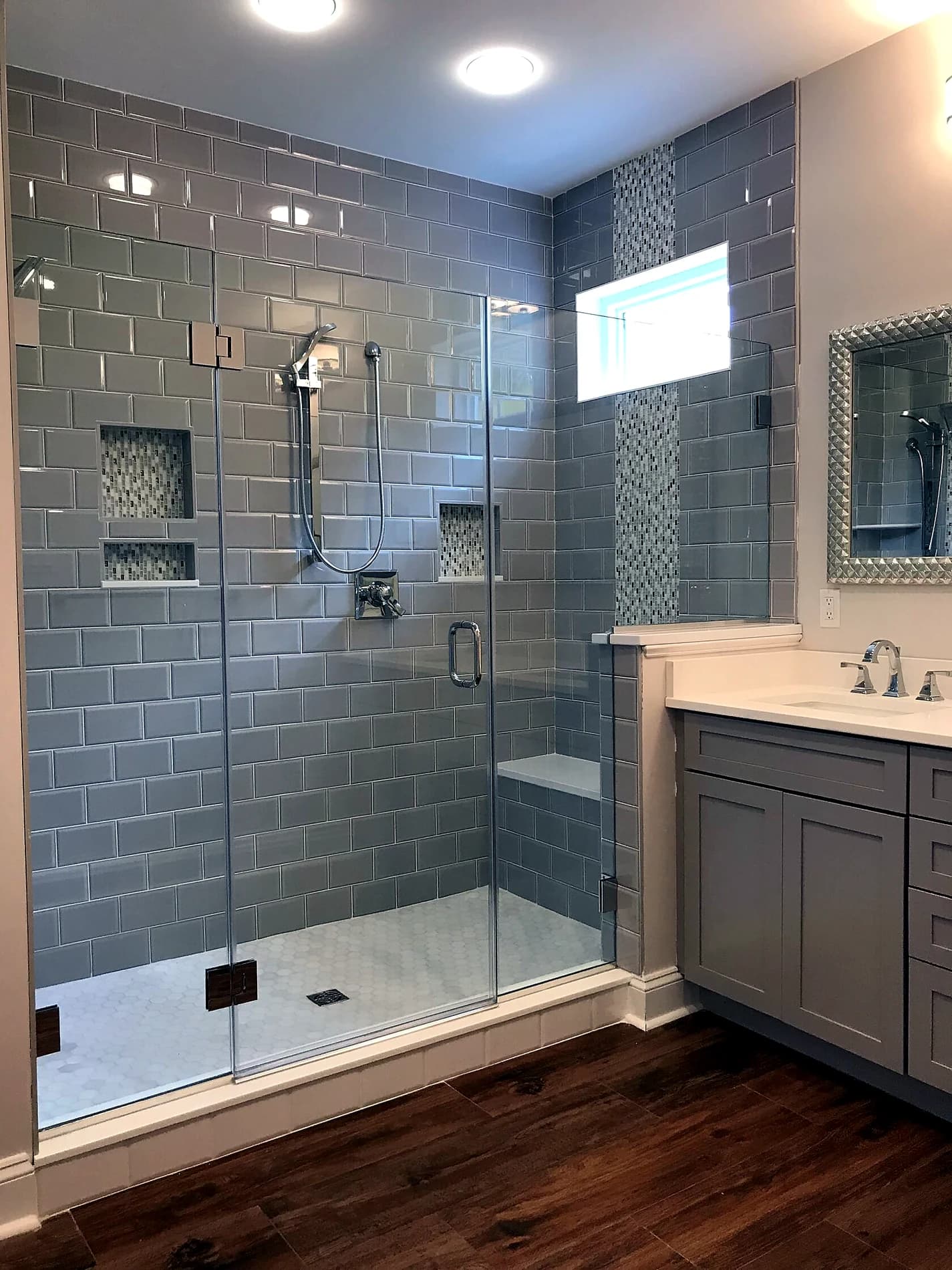 Gray tile shower with glass enclosure and vanity