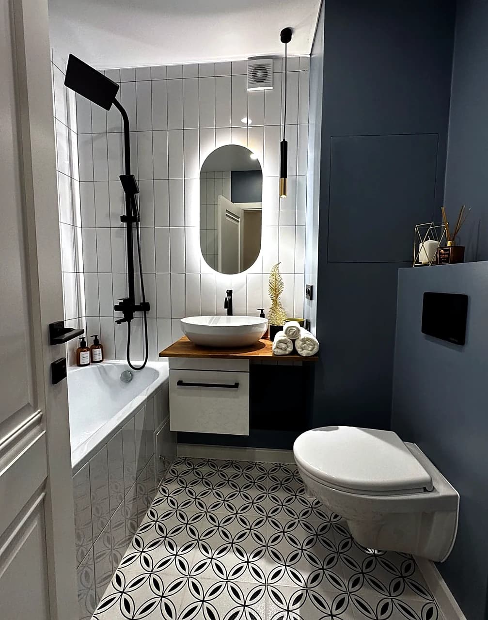 Finished powder room with patterned floor and dark wall detail
