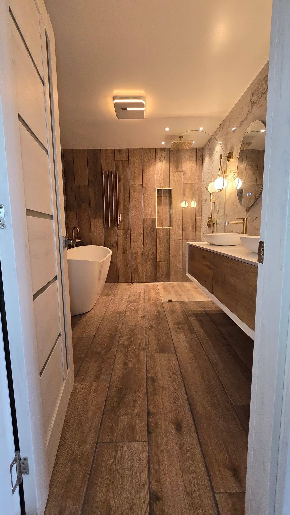 Bathroom remodel with wood-look tile, freestanding tub, glass shower, and floating vanity