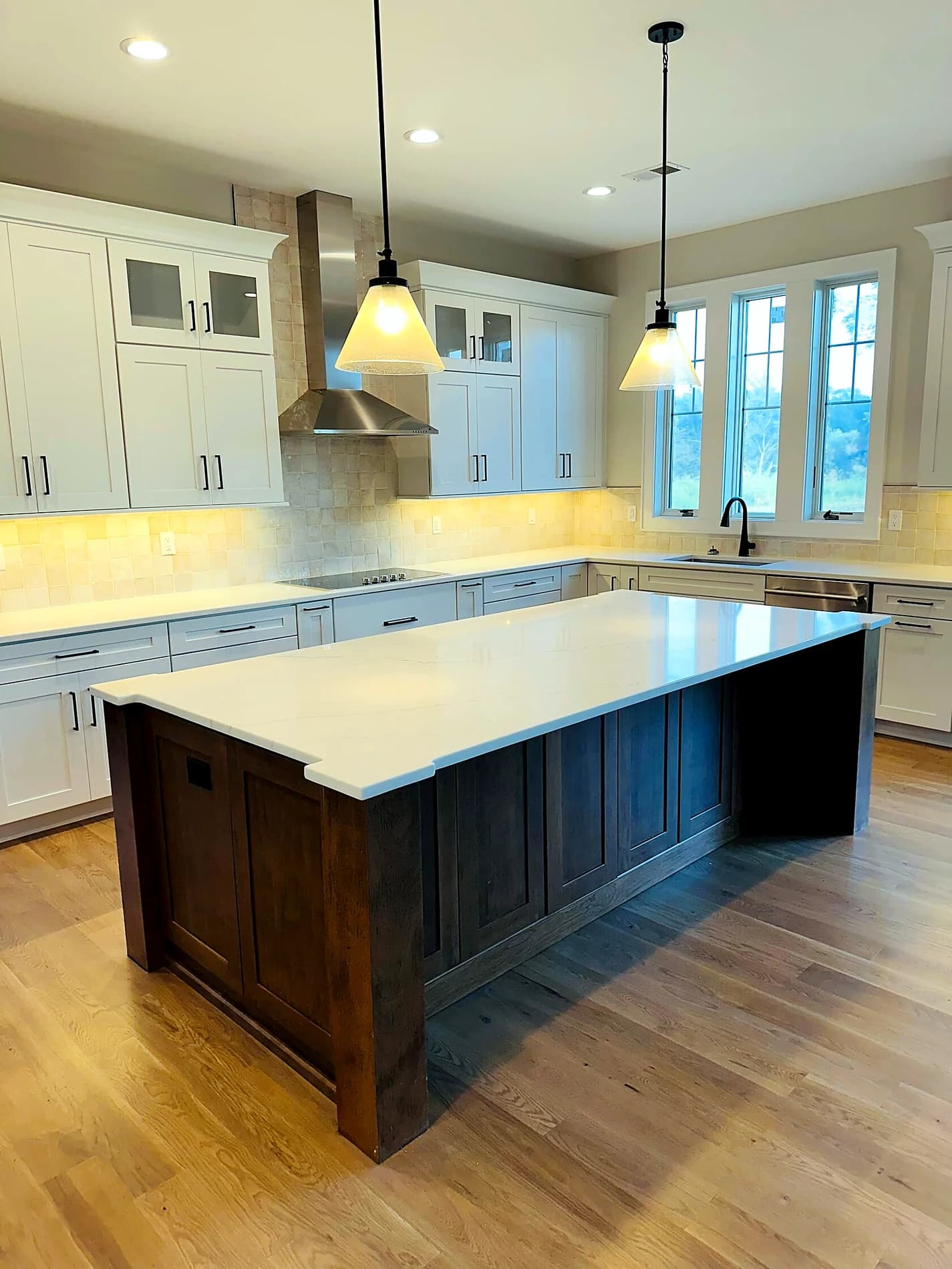 Finished kitchen with large island, pendant lighting, and wood floors