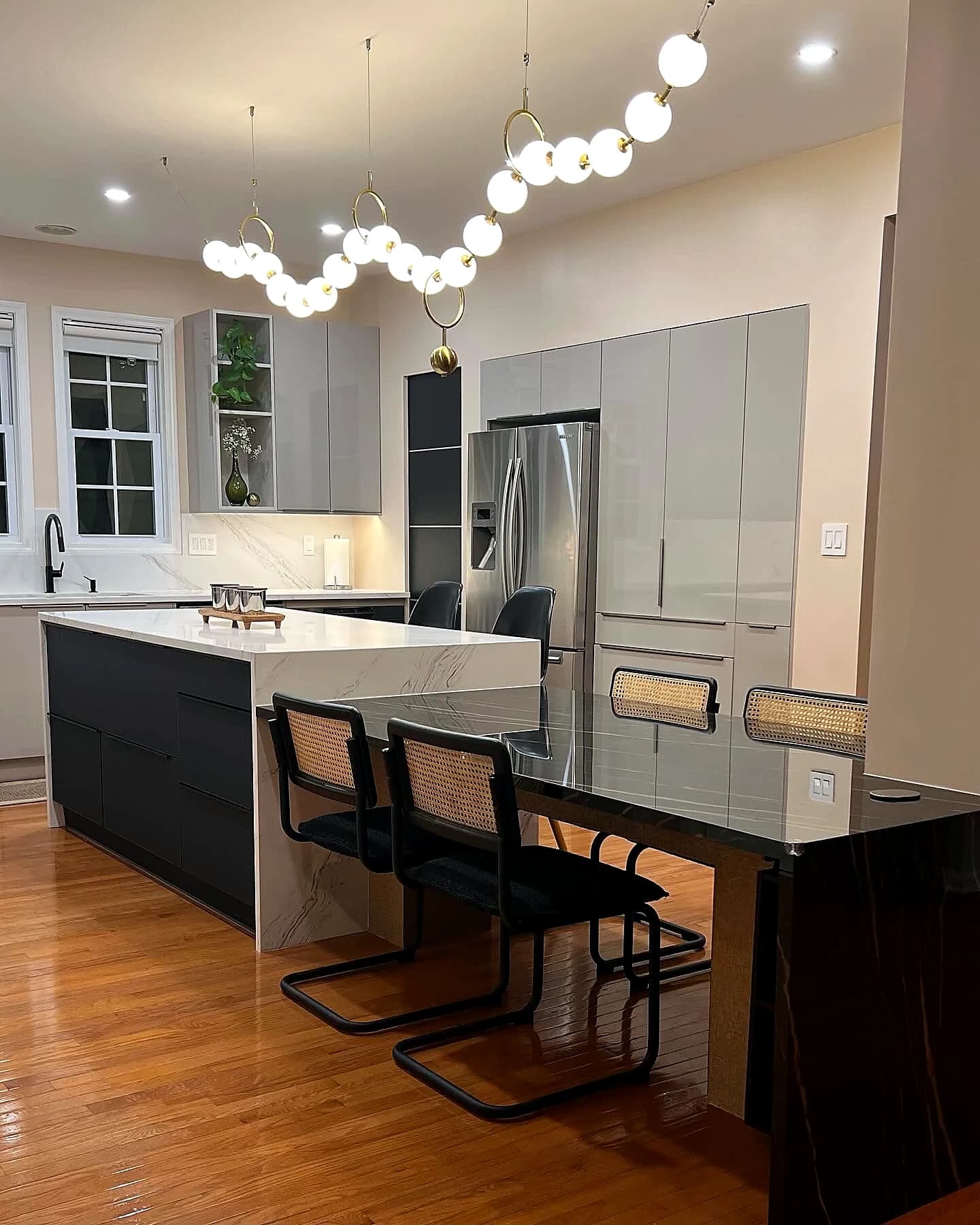 Finished kitchen remodel with polished island and statement lighting
